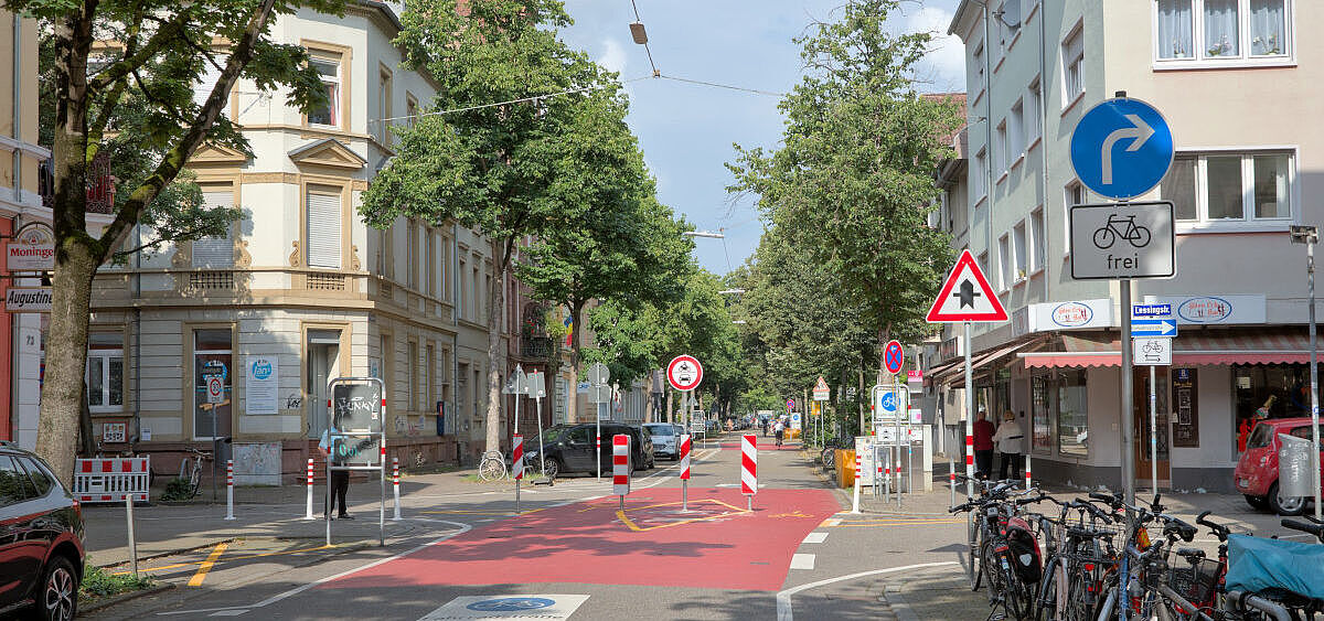 Modaler Filter Sophienstraße/Lessingstraße mit Abbiegegebot Foto des modalen Filters an der Kreuzung Sophienstraße/Lessingstraße. Zu sehen ist eine Reihe Sperrpfosten quer über die Fahrbahn und ein Verkehrszeichen "vorgeschriebene Fahrtrichtung rechts, Radfahrer frei"